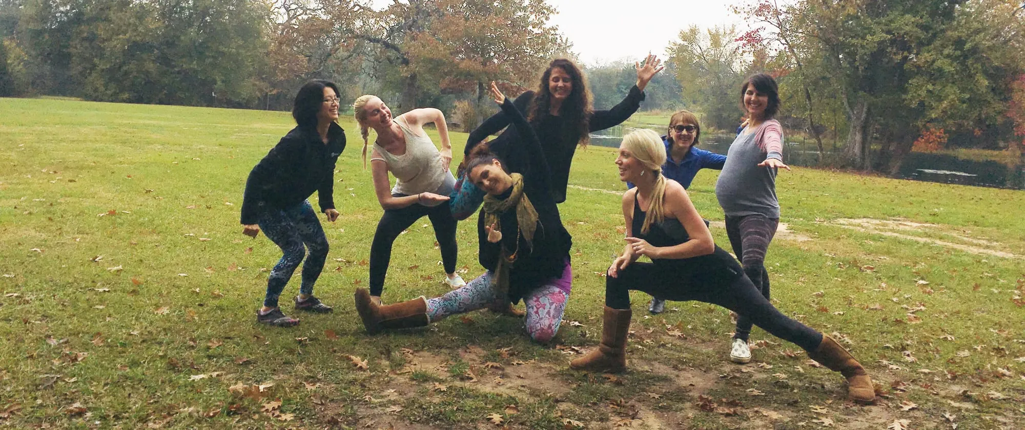 A Poppy training cohort of yoga teachers and birth workers, gathered and smiling after graduation